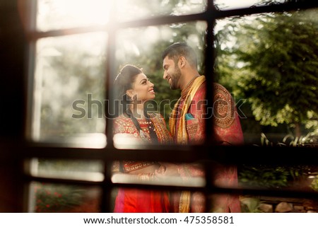 Hot summer sun shines over the Indian newlyweds hugging behind the window