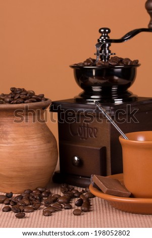 Vintage coffee grinder, cup with a drink and a pitcher with roasted beans