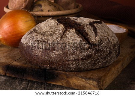 Rye bread, baked potatoes and salt on a wooden board