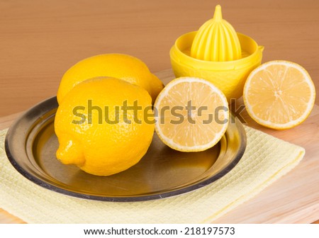 Some lemons on a plate and squeezer