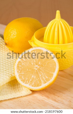Two lemons on a table and squeezer