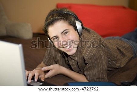 High School student studying and listening to music in his bed
