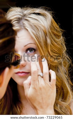 Makeup artist applies makeup to photoshoot model
