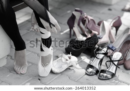 Ballerina Putting Pointe Ballet Shoes on her Feet