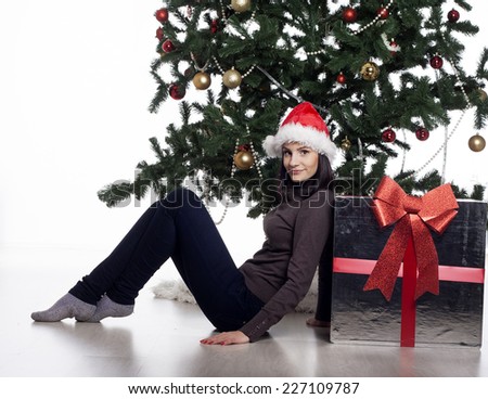 Young beautiful woman near new year tree with present