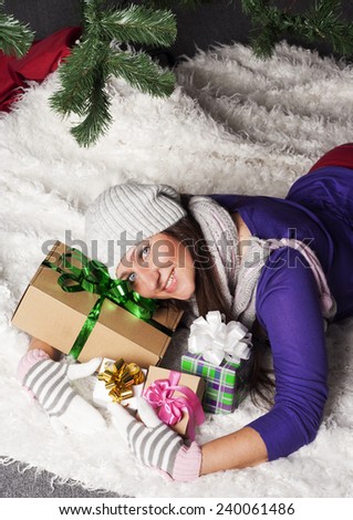 Young beautiful woman near new year tree with present