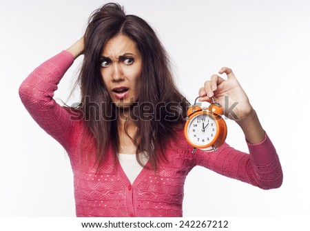 Young pretty shocked woman holding clocks in hands