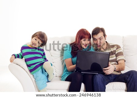 Father, mother and son sitting on the sofa with notebook over white background