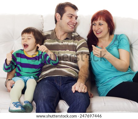 Father, mother and son sitting on the sofa over white background