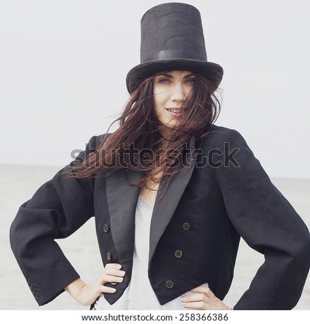 Happy young woman wears cylinder and tail coat