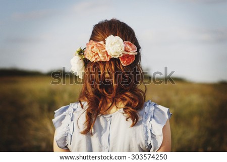 Picture of girl standing back with flowers in head