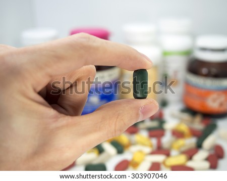 taking a vitamin tablet,Pills or vitamin in Medicine bottles with pill box,Vitamin, drug,multivitamin, herbal supplement capsules, Colorful,pills and tablets, background