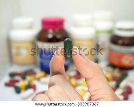 taking a vitamin tablet,Pills or vitamin in Medicine bottles with pill box,Vitamin, drug,multivitamin, herbal supplement capsules, Colorful,pills and tablets, background