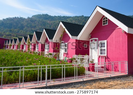Single pink house with brown roof and blue sky connecting in same row