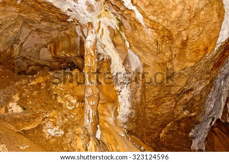 Inside view of an underground cavern or cave with stalagmites and stalactites. Limestone formations on the wall of an underground cave. Stalactite and stalagmite formations in the cave.
