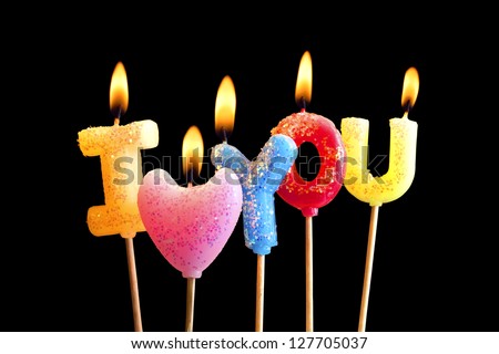 Colorful burning candles making 'I love you' isolated on black (clipping path included)
