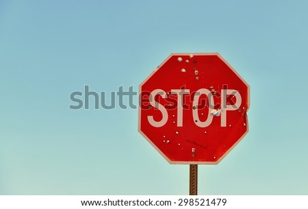 Bullet ridden Stop Sign