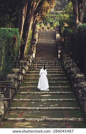 beautiful stylish italian brunette bride on the background long stairs park of  tivoli italy