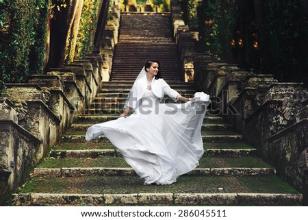 beautiful stylish italian brunette bride on the background long stairs park of  tivoli italy