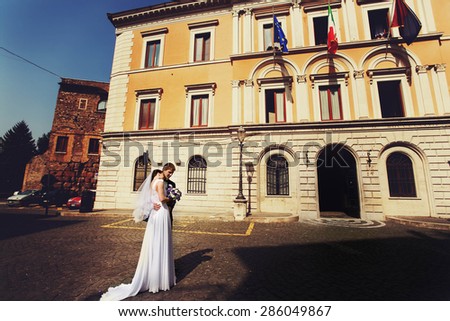 beautiful young gorgeous stylish brunette bride and groom on the background tivoli city hall italy