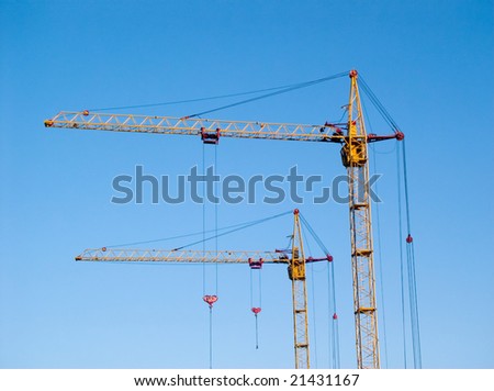 two tall yellow lifting cranes