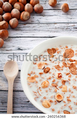 Muesli with nuts and milk on a wooden table