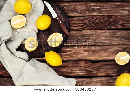 Scattered yellow lemons on the old wooden background. Rural or rustic style. top view. Copy space. free text space. close up. Old wooden table. Toned in vintage style