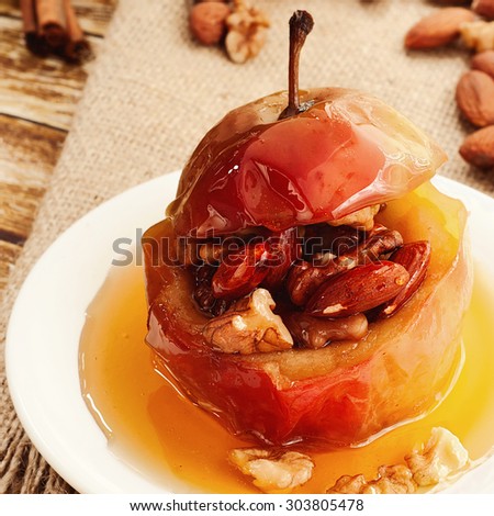 Dessert of baked apples stuffed with nuts and drizzled with honey. Closeup. Free space for text. Copy space