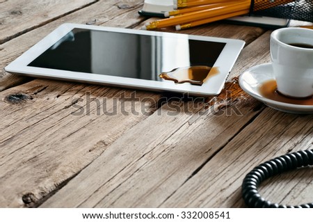 Spilled coffee on white tablet computer on the office table. Copy space. Free space for text