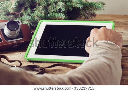 Man\'s hand close-up clicks on a blank screen tablet computer. Photo toned vintage style