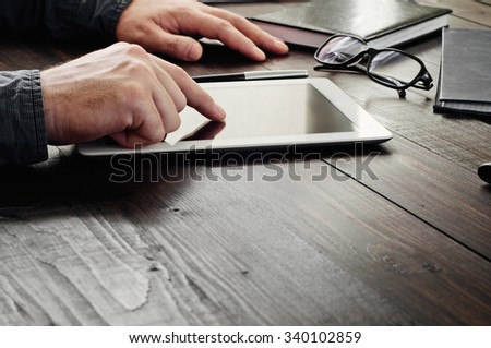 The man clicks on screen tablet computer close up. Man working with a tablet computer. Copy space. Free space for text