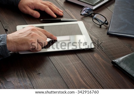 Man working with a tablet computer. Closeup the man clicks on screen tablet computer. Copy space