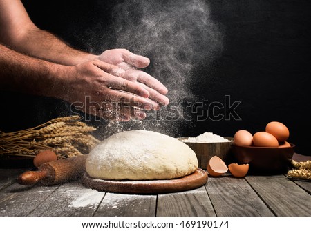 Baker cooking bread. Man slaps flour over the dough. Man Making bread