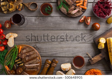 Frame of different food cooked on the grill. Grilled steak, grilled vegetables and red wine. Top view
