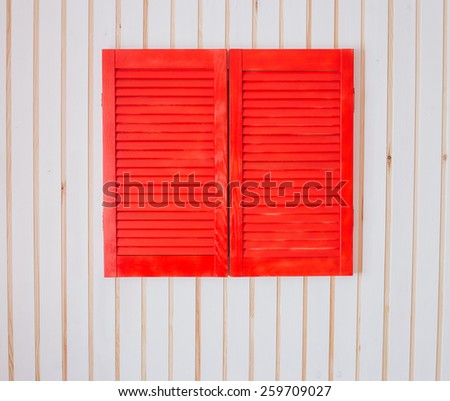 Red wooden shutters on a white wooden wall. Eco style