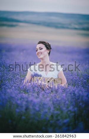 Beautiful young woman in a white dress posing in a lavender field