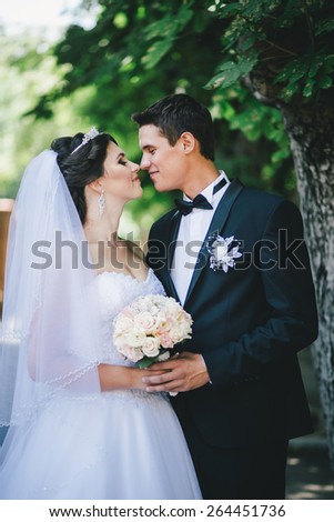 Happy and beautiful bride and groom posing in a park. Wedding day