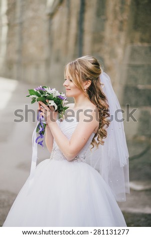 Beautiful bride in wedding dress on her wedding day with medieval castle on the background