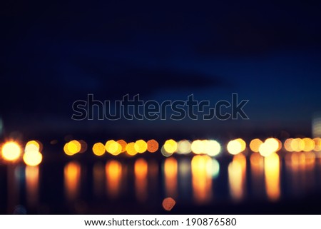defocused street lamps and reflection on a water, night city life