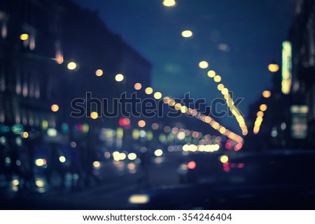 defocused night city life: cars, people and street lamps, retro style