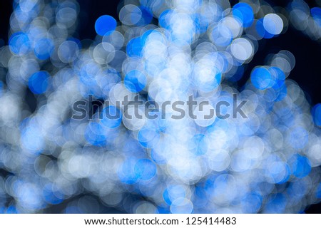 Blue white sparkles and circles bokeh abstract, blurred and out of focus lights on Christmas tree, glimmer dark mood light background in horizontal orientation, nobody.