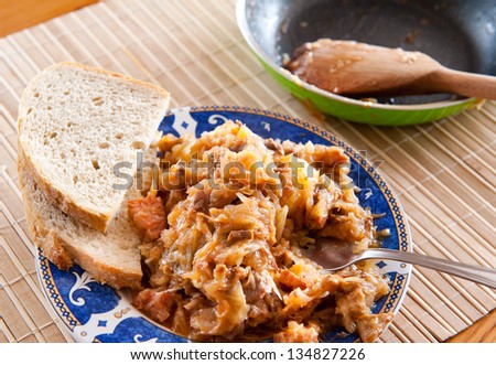 Portion of hot Polish bigos with bread on plate, traditional meal known as a hunters stew, popular dish in Poland is served on the Second Day of Christmas. Meal on sauerkraut called kapusta kiszona.