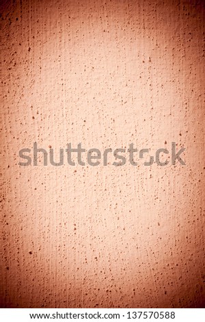 Grained paint brown wall texture abstract with dark vignette, wall surface bright in central part detail background in vertical orientation, nobody.