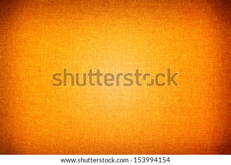 Orange texture cloth background bright in central part with dark vignette, material abstract in horizontal orientation, nobody.