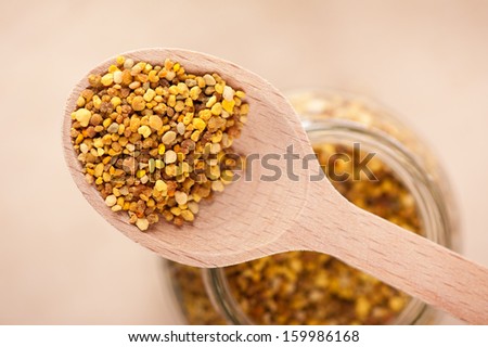 Fresh pollen grains portion on wooden spoon, plants seeds are healthy food ingredient. Horizontal orientation, studio shot.