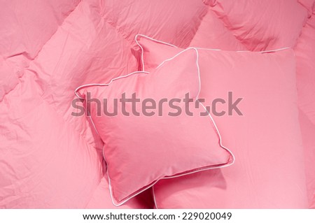 Cotton pink fluffy two pillows and duvet without cover, eiderdown filled with fluff or feathers. Horizontal orientation, nobody.