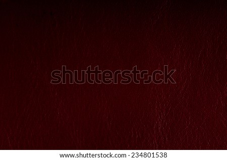 Maroon leather sheet texture abstract with black vignette, material grunge surface background in horizontal orientation, digitally altered, nobody.
