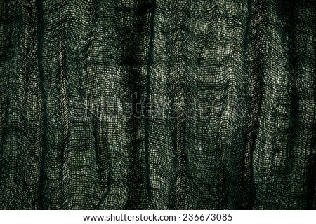 Green grunge cloth texture, dark toned fabric sheet textured surface, woven fiber rough abstract in horizontal orientation, image digitally altered, nobody.