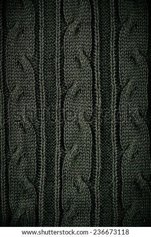 Green plait sweater cloth texture abstract, dark rough plain seamless surface background in vertical orientation, nobody.