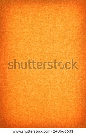 Orange smooth texture cloth background bright in central part with dark vignette, material abstract in vertical orientation, nobody.